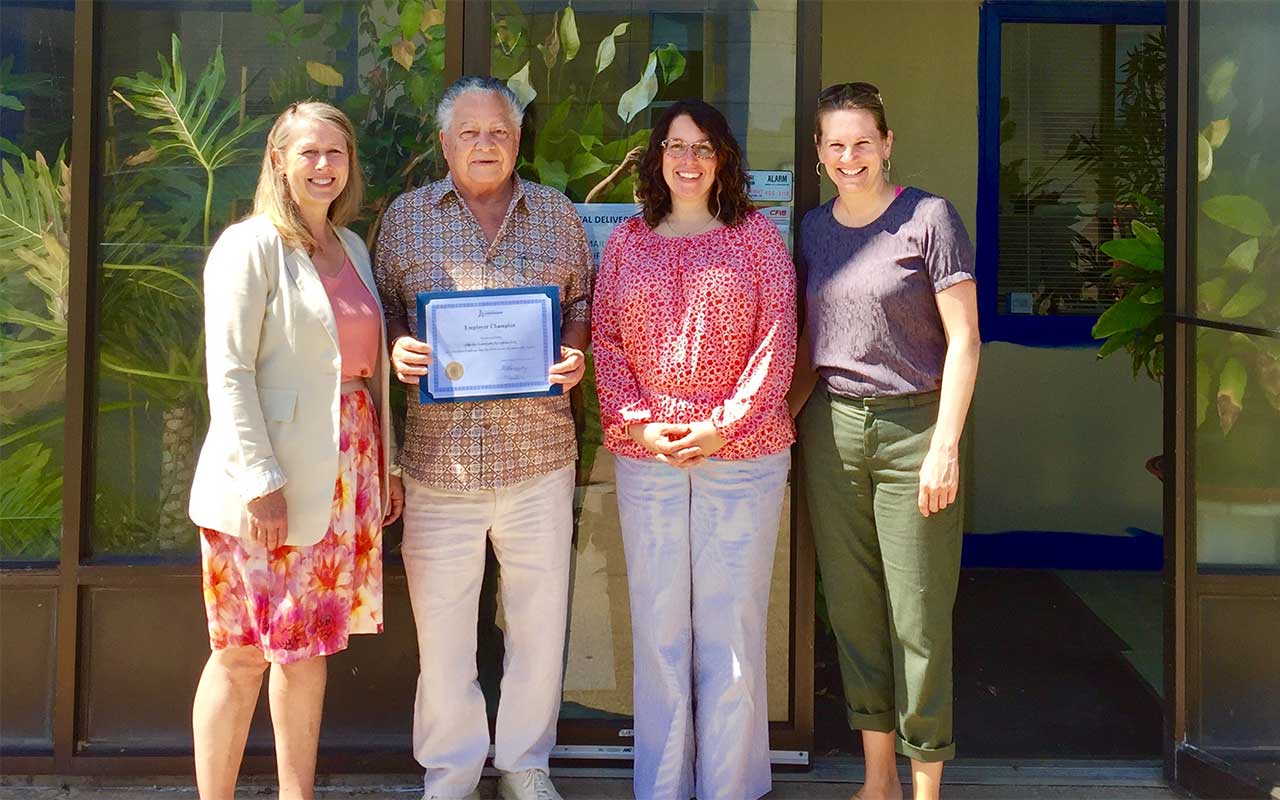 Employees of Atlantic Automatic Sprinklers gather around their Employer Champion award