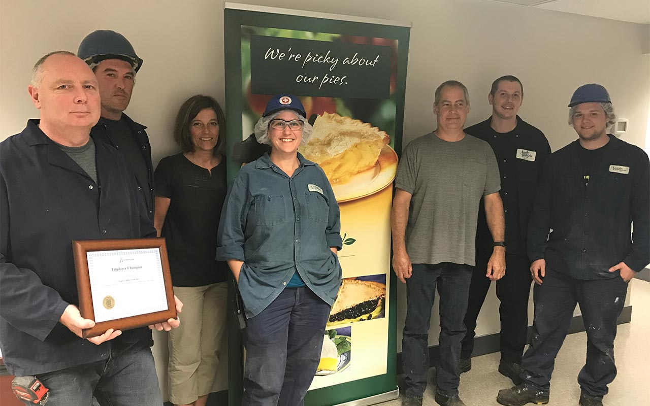 Employees of Apple Valley gather around their Employer Champion award