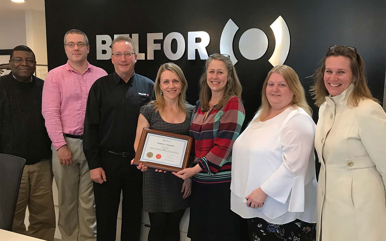 Six employees of Belfor pose of a photo with their Employer Champion award