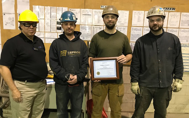 Employees of CTS Containers gather around their Employer Champion award