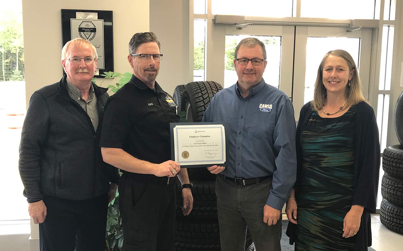 Employees of Canso Ford Sales and Port Hawkesbury Collision Center gather around their Employer Champion award