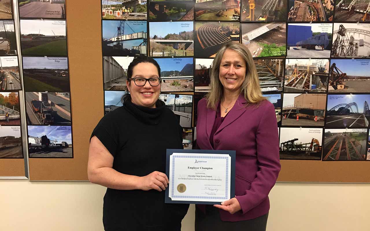 Employees of Cherubini Metal Works gather around their Employer Champion award