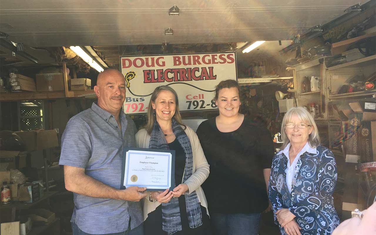 Employees of Doug Burgess Electrical gather around their Employer Champion award