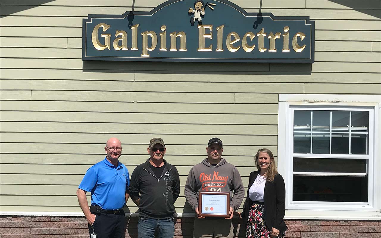 Employees of Galphin Electric gather around their Employer Champion award
