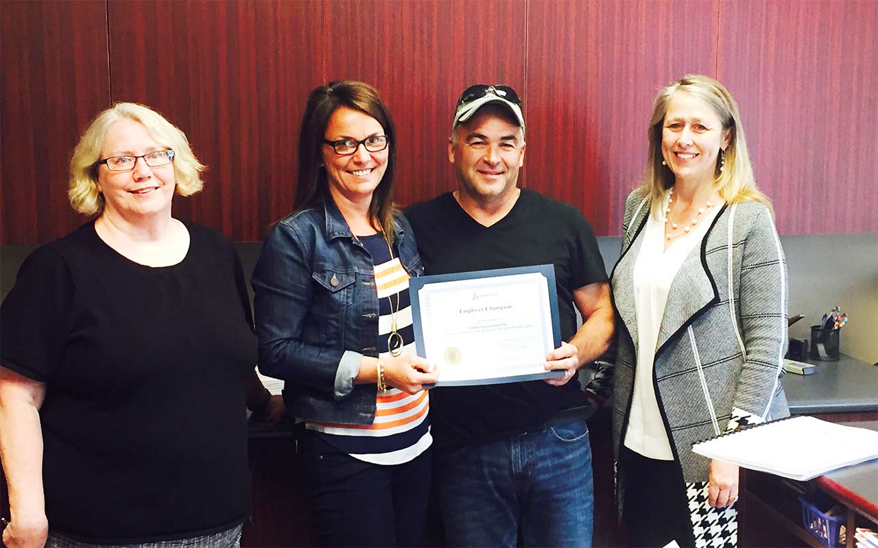 Employees of Garian Construction gather around their Employer Champion award