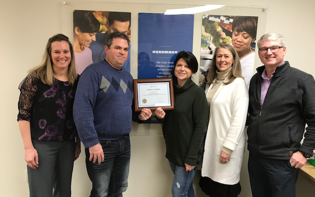 Employees of Hussman Canada Inc. gather around their Employer Champion award