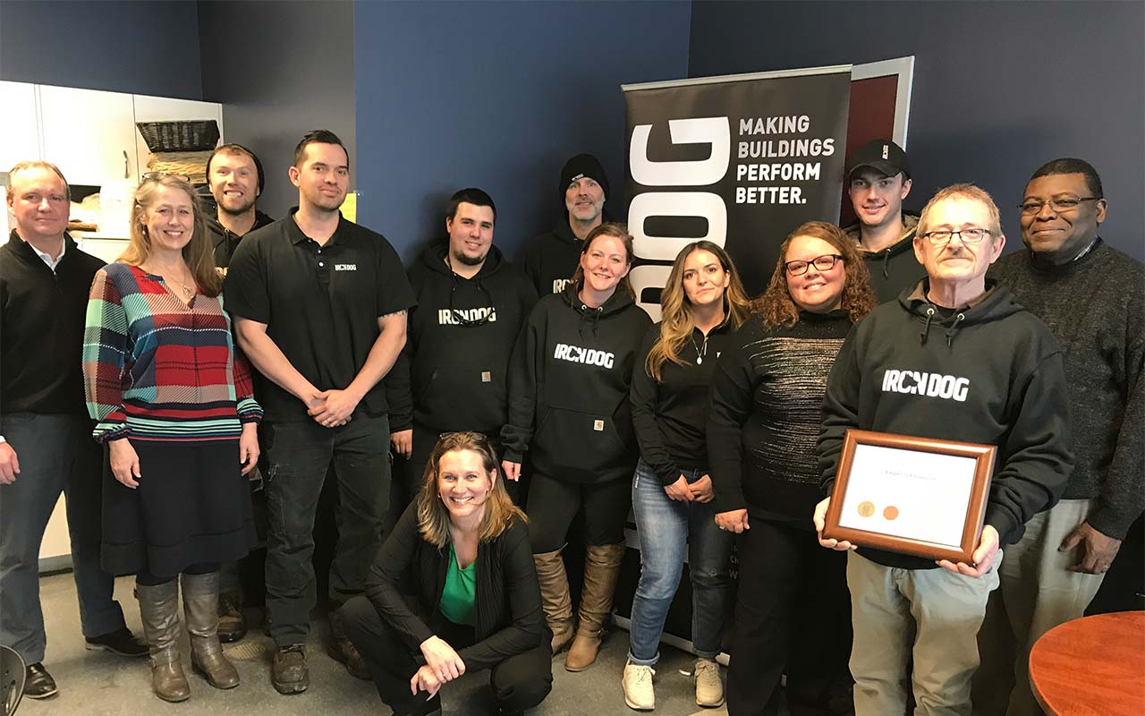 Eleven employees of Iron Dog gather for a photo with their Employer Champion award