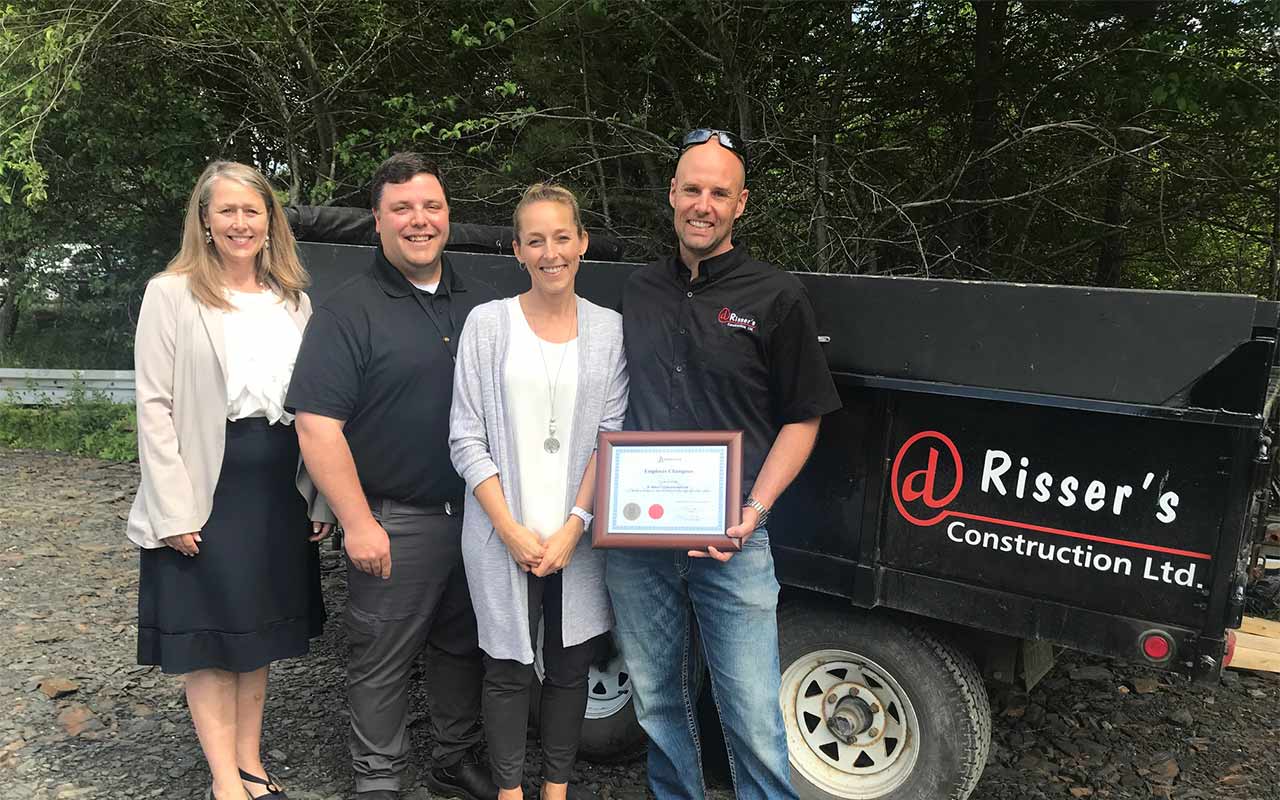 Employees of Risser's Construction gather around their Employer Champion award