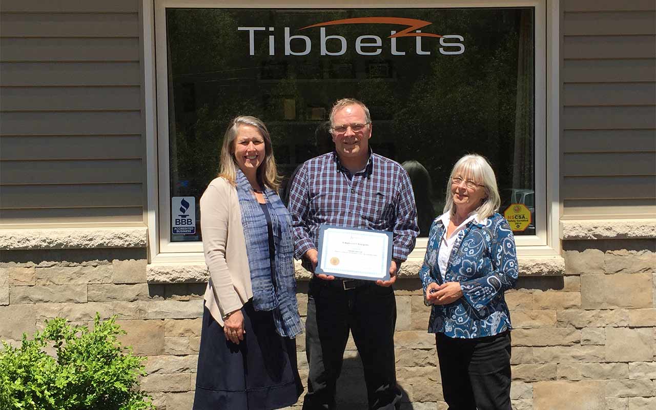 Employees of Tibbetts Electrical Contracting gather around their Employer Champion award
