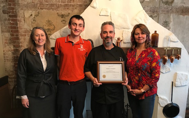 Employees of The Old Triangle gather around their Employer Champion award