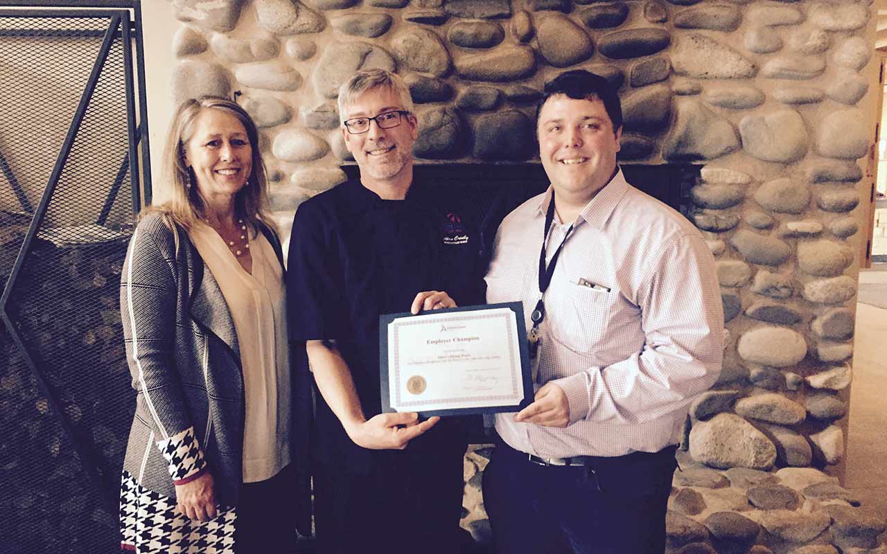 Employees of White Point - Elliott's Dining Room gather around their Employer Champion award