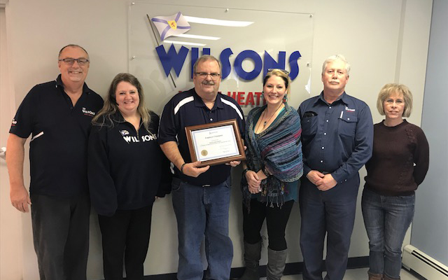 Employees of Wilson's Home Fuels gather around their Employer Champion award