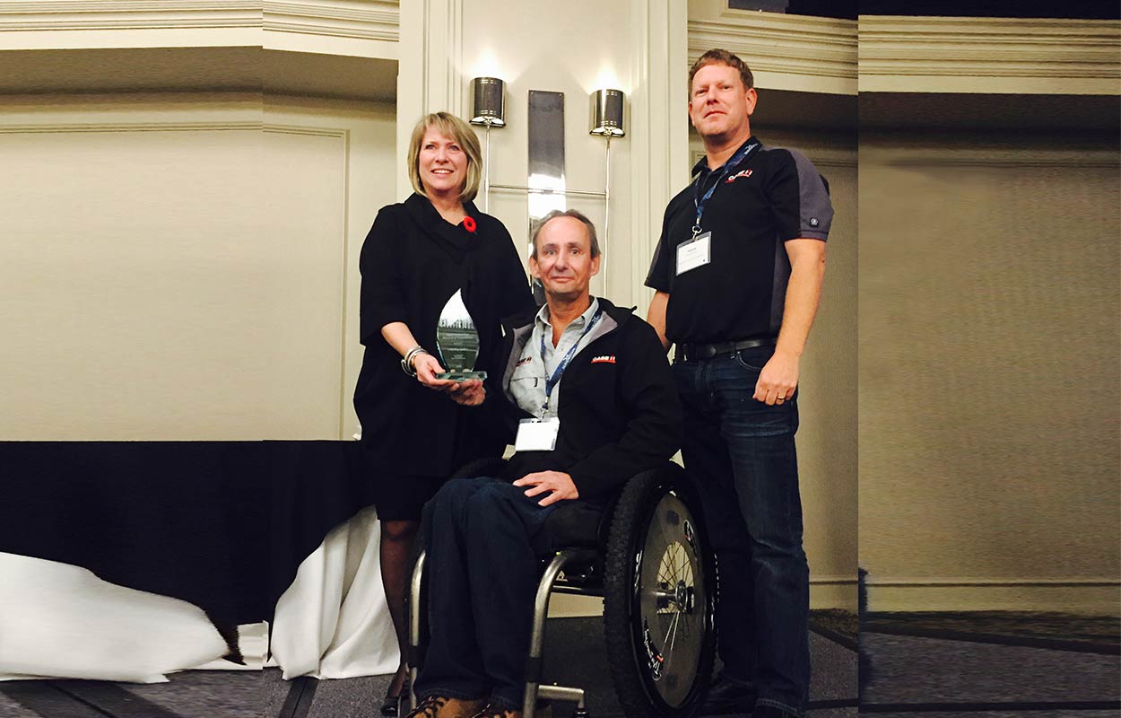 Employees of Vanoostrum Farm Equipment gather around their Employer Champion award