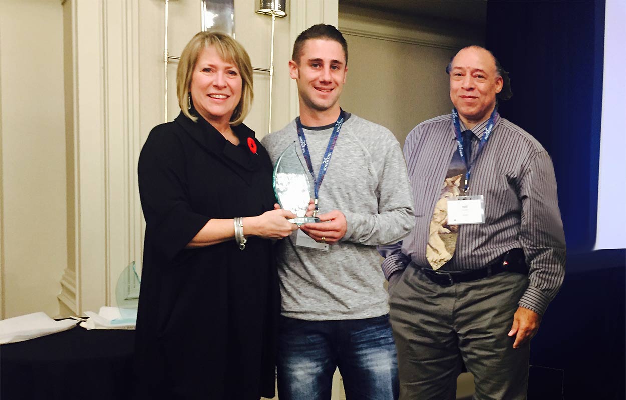 Employees of Skilled Masons and Restoration Inc. gather around their Employer Champion award