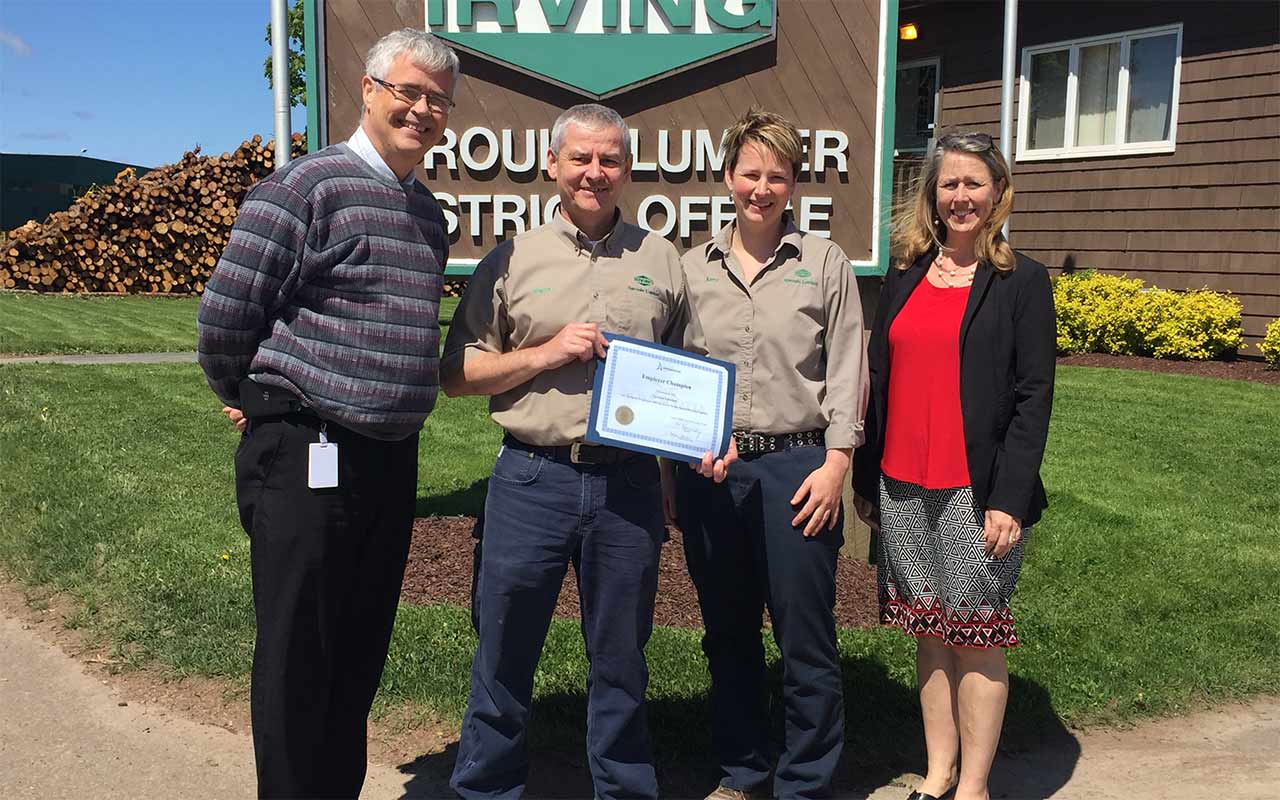 Employees of Sproule Lumber gather around their Employer Champion award