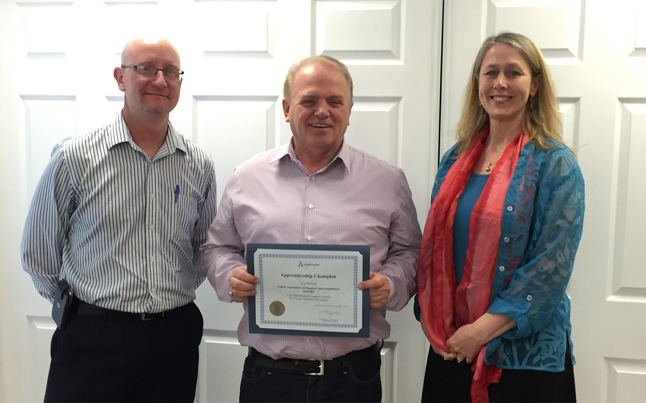 Employees of UA Local 682 gather around their Employer Champion award