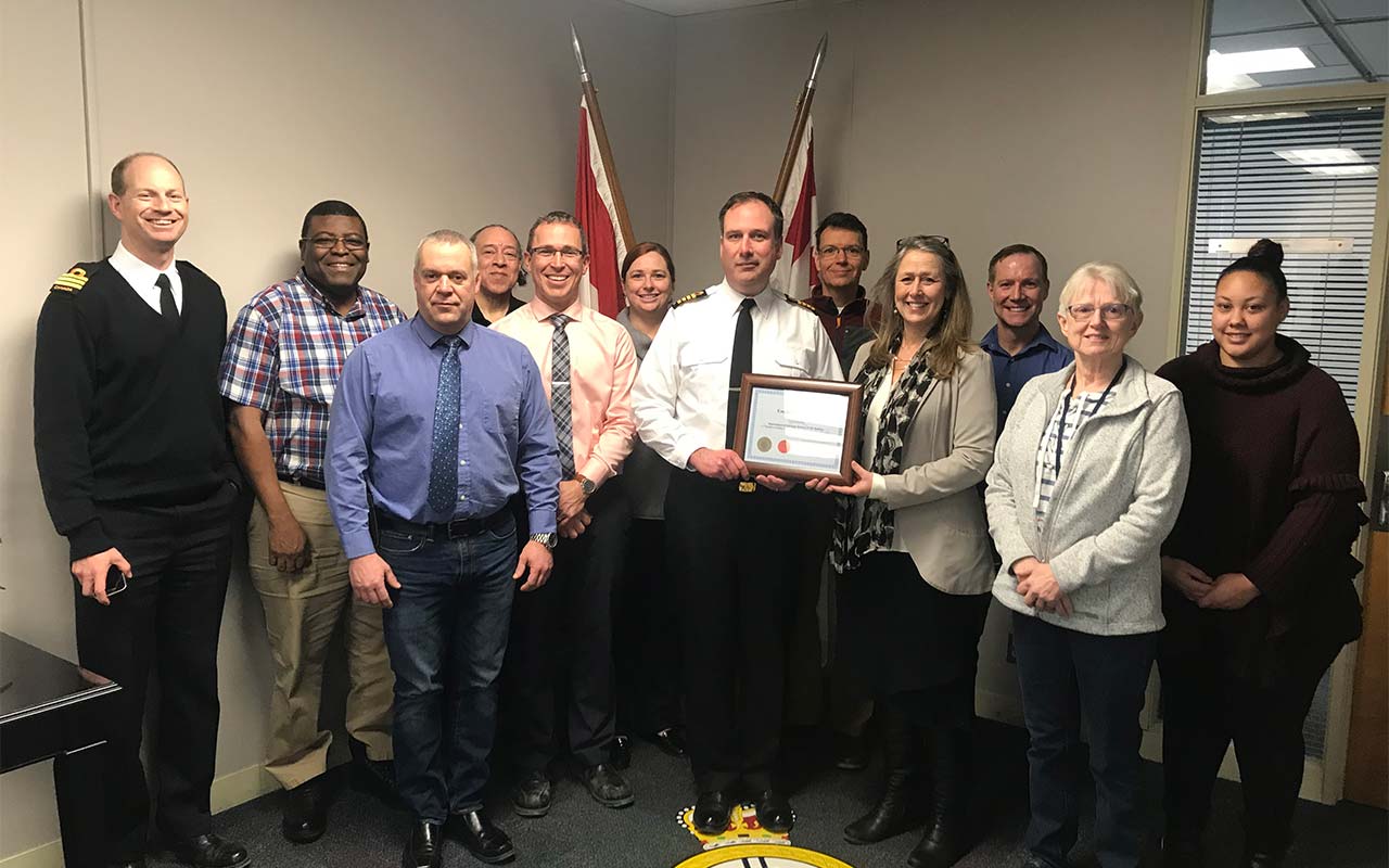 Employees of the Department of National Defence gather around their Employer Champion award