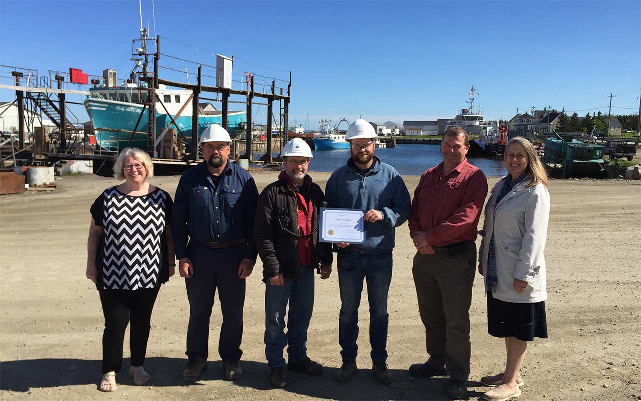 Employees of Theriault & Sons Ltd. gather around their Employer Champion award