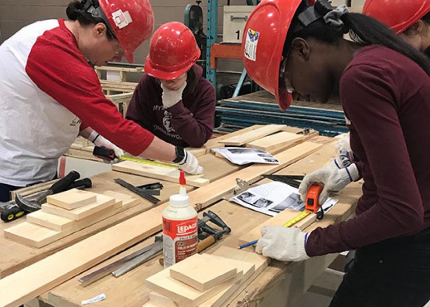 Female youth apprentices doing carpentry indoors