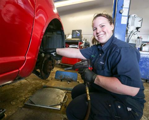 Female Automotive Service Technician working indoors